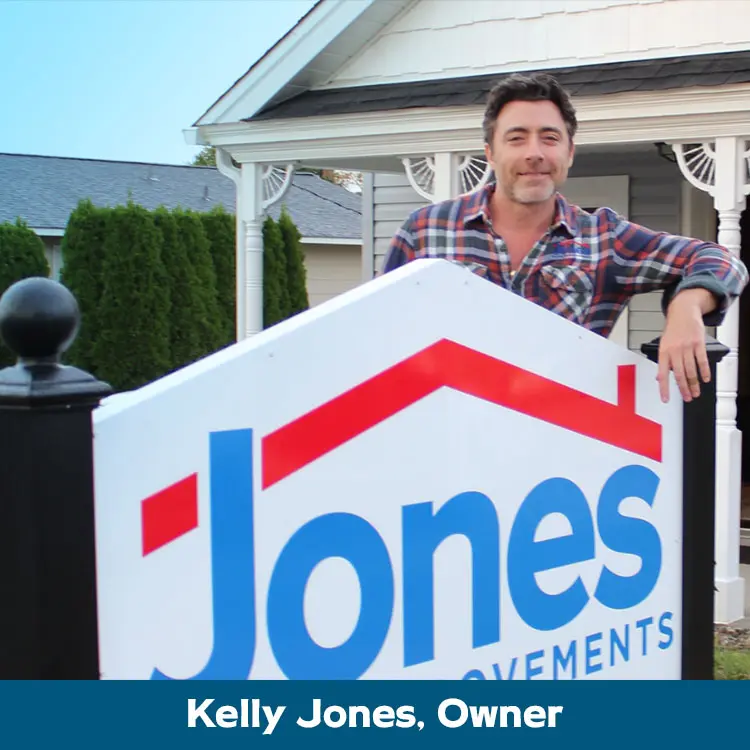 Kelly Jones, a home improvement contractor, stands proudly in front of his home.
