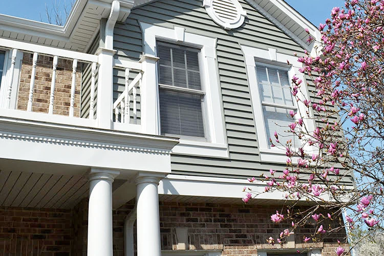 A home improvement contractor transforms a house with a balcony into an inviting space with new siding and trim.