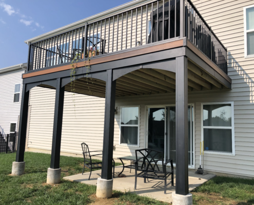 A new deck with a black railing and patio furniture.