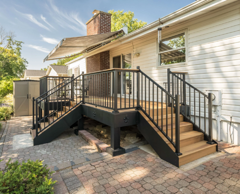 A new deck with stairs leading to a backyard.