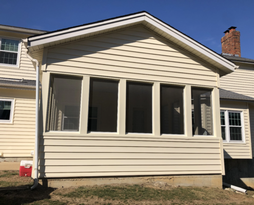 A house with a screened in porch that requires siding replacement.